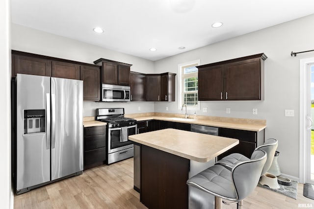 1604 Savile Ln, Washington, IL 61571 - kitchen featuring appliances with stainless steel finishes, light wood-type flooring, dark brown cabinets, light countertops, and a kitchen island