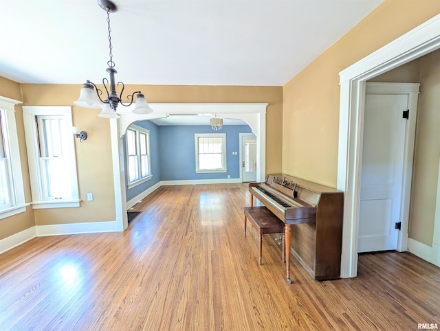 1101 S 4th St, Pekin, IL 61554 - unfurnished room featuring a chandelier, wood finished floors, and arched walkways