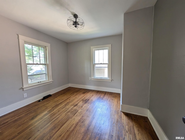 1101 S 4th St, Pekin, IL 61554 - empty room with plenty of natural light and dark wood-style floors