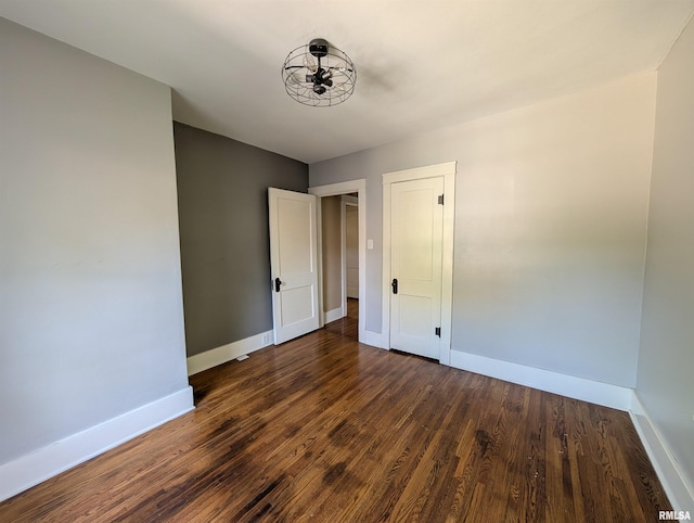 1101 S 4th St, Pekin, IL 61554 - unfurnished bedroom featuring baseboards and dark wood-type flooring