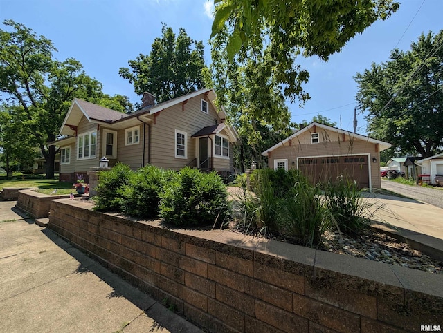 1101 S 4th St, Pekin, IL 61554 - view of side of home with a chimney, an outdoor structure, and a detached garage
