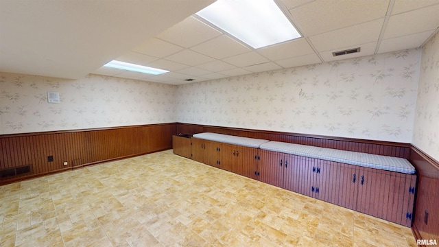 1729 W Willow Wood Dr, Peoria, IL 61614 - empty room featuring wainscoting, a paneled ceiling, wood walls, and tile patterned floors
