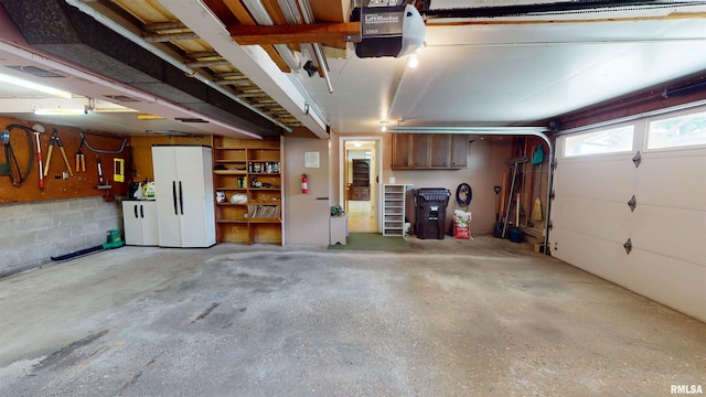 1729 W Willow Wood Dr, Peoria, IL 61614 - garage featuring a garage door opener and freestanding refrigerator