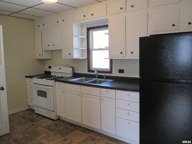 1810 W Latrobe St, Peoria, IL 61605 - kitchen featuring freestanding refrigerator, white gas stove, dark countertops, white cabinets, and a paneled ceiling