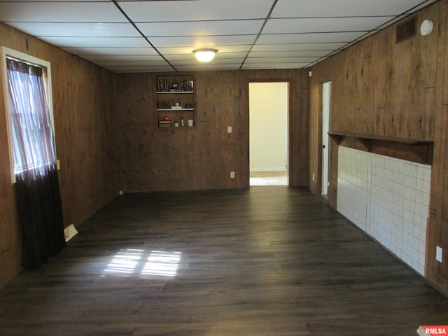1810 W Latrobe St, Peoria, IL 61605 - unfurnished living room with wooden walls, a paneled ceiling, and dark wood-style flooring