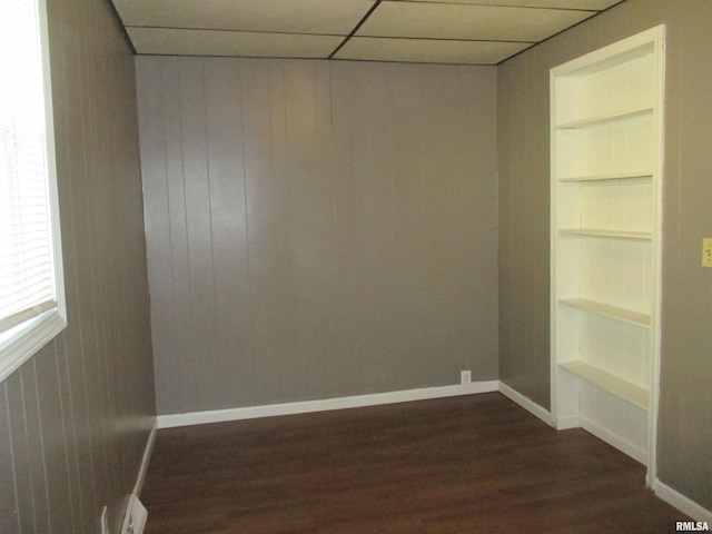 1810 W Latrobe St, Peoria, IL 61605 - empty room featuring built in shelves, dark wood-type flooring, and wood walls