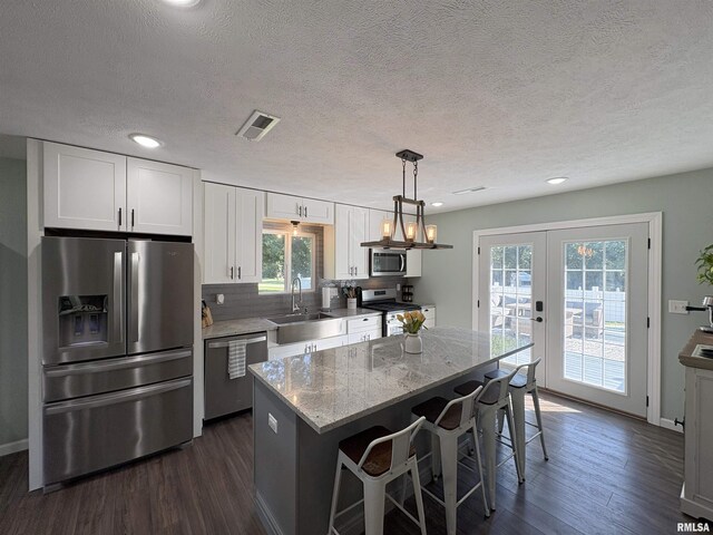 276 E Far Hills Dr, East Peoria, IL 61611 - kitchen featuring appliances with stainless steel finishes, dark wood finished floors, white cabinets, a center island, and recessed lighting