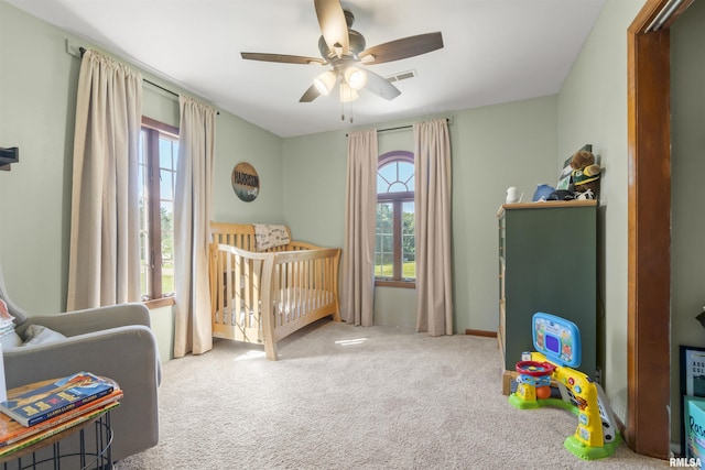 276 E Far Hills Dr, East Peoria, IL 61611 - carpeted bedroom with multiple windows, a nursery area, and a ceiling fan