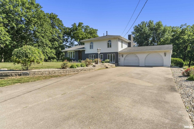 276 E Far Hills Dr, East Peoria, IL 61611 - tri-level home with an attached garage, driveway, and a chimney