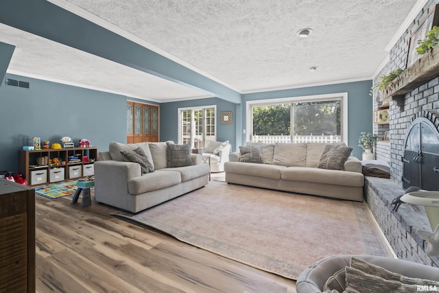 276 E Far Hills Dr, East Peoria, IL 61611 - living room with wood finished floors, ornamental molding, a textured ceiling, and a brick fireplace
