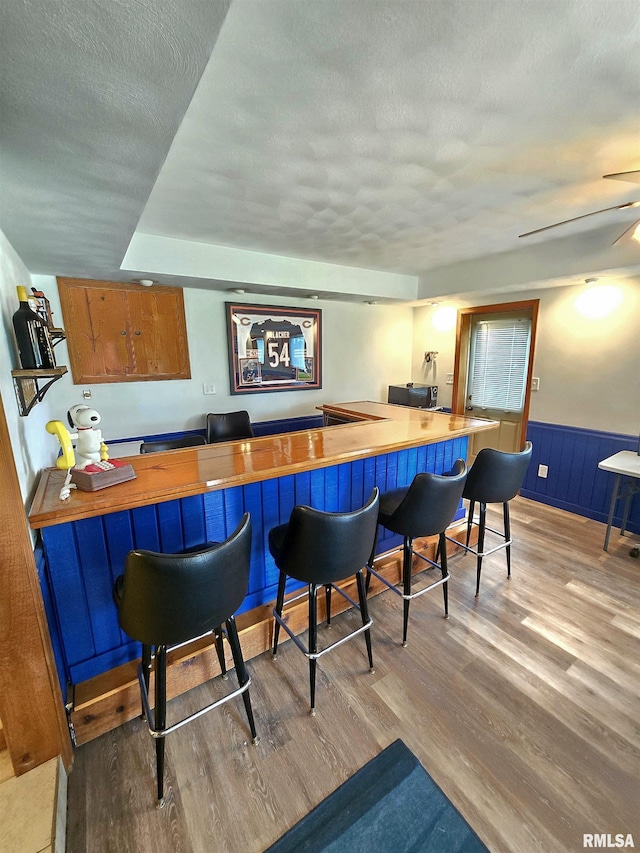 1515 Lakeview Rd N, Dahinda, IL 61428 - indoor bar with wood finished floors, a textured ceiling, and wainscoting