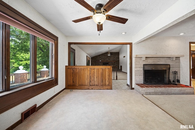 22475 N Main St, Morton, IL 61550 - unfurnished living room with a brick fireplace, ceiling fan, vaulted ceiling, a textured ceiling, and light carpet