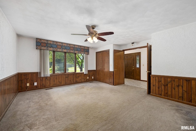22475 N Main St, Morton, IL 61550 - carpeted empty room with wood walls, a wainscoted wall, and ceiling fan