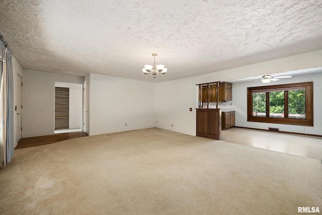 22475 N Main St, Morton, IL 61550 - unfurnished living room with a chandelier, light colored carpet, ceiling fan, and a textured ceiling