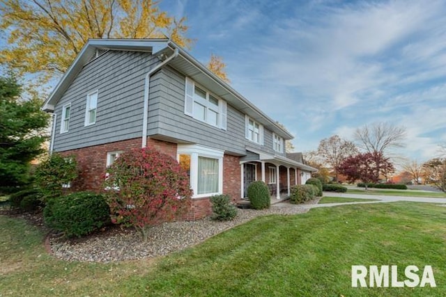 210 W Wolf Rd, Peoria, IL 61614 - view of front facade featuring a front yard and brick siding