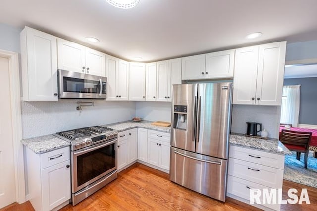 210 W Wolf Rd, Peoria, IL 61614 - kitchen with appliances with stainless steel finishes, white cabinetry, light stone counters, light wood-type flooring, and recessed lighting
