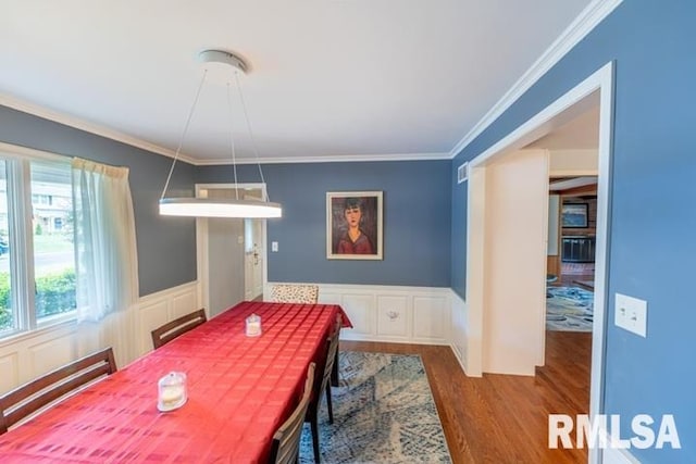 210 W Wolf Rd, Peoria, IL 61614 - dining space featuring wood finished floors, a decorative wall, ornamental molding, and a wainscoted wall