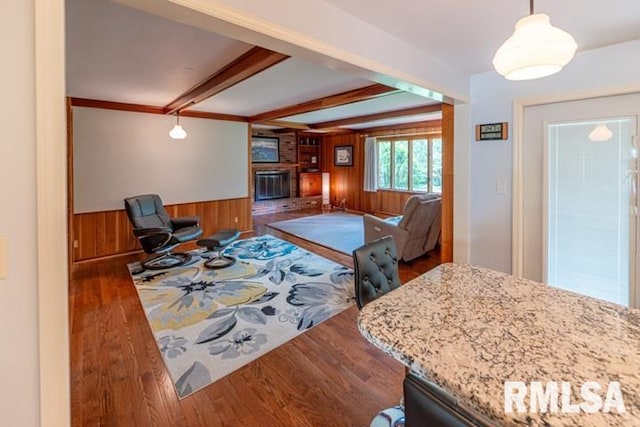 210 W Wolf Rd, Peoria, IL 61614 - living area with wooden walls, wood finished floors, a fireplace, beam ceiling, and wainscoting
