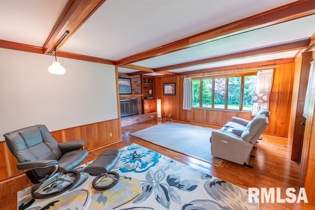 210 W Wolf Rd, Peoria, IL 61614 - living room with wood walls, beamed ceiling, wood finished floors, a brick fireplace, and wainscoting