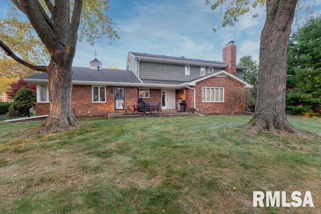 210 W Wolf Rd, Peoria, IL 61614 - back of house with brick siding, a lawn, and a patio