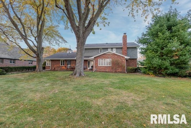 210 W Wolf Rd, Peoria, IL 61614 - rear view of property featuring a chimney, a yard, and brick siding