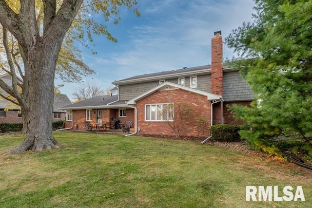 210 W Wolf Rd, Peoria, IL 61614 - rear view of property featuring a chimney, a lawn, brick siding, and a patio area