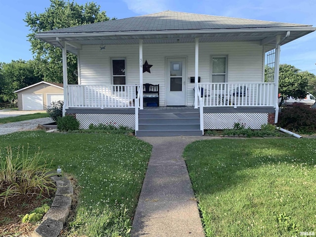 519 E Davis St, Bushnell, IL 61422 - view of front facade featuring a porch, a front lawn, and a detached garage