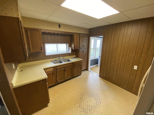 1228 E Lake Ave, Peoria Heights, IL 61616 - kitchen featuring wooden walls, light countertops, a drop ceiling, light flooring, and brown cabinetry