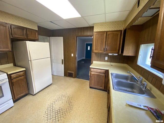 1228 E Lake Ave, Peoria Heights, IL 61616 - kitchen with a paneled ceiling, white appliances, wood walls, and light countertops