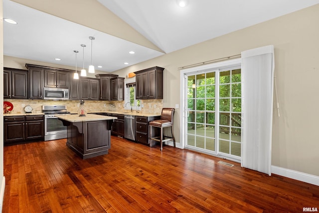 2627 W Lake Pointe Ter, Peoria, IL 61614 - kitchen with stainless steel appliances, dark brown cabinets, dark wood-style floors, lofted ceiling, and decorative backsplash
