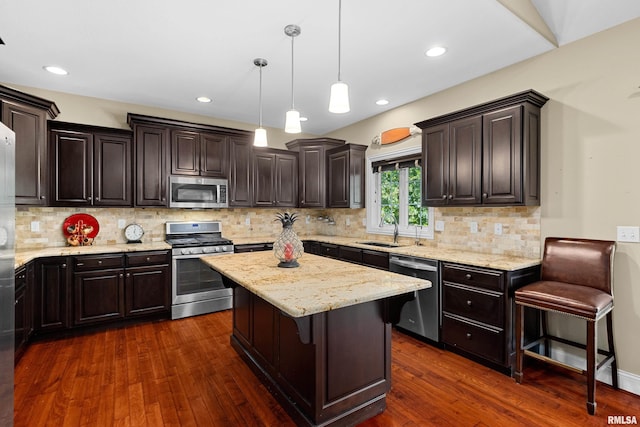 2627 W Lake Pointe Ter, Peoria, IL 61614 - kitchen featuring appliances with stainless steel finishes, dark wood-type flooring, a center island, light stone counters, and dark brown cabinetry