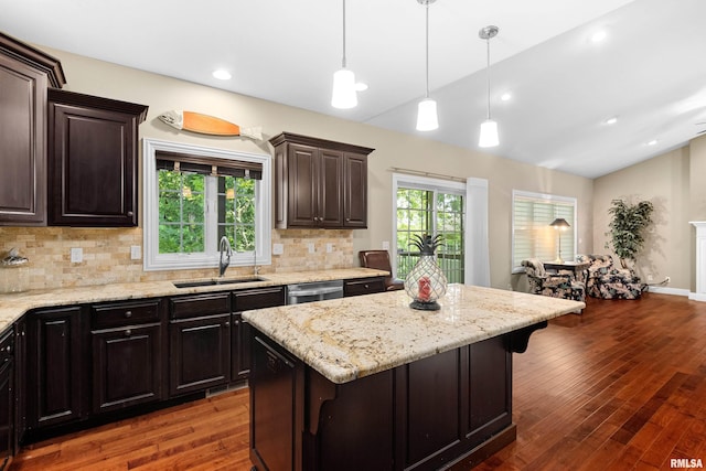 2627 W Lake Pointe Ter, Peoria, IL 61614 - kitchen with lofted ceiling, tasteful backsplash, a kitchen bar, hardwood / wood-style flooring, and light stone countertops