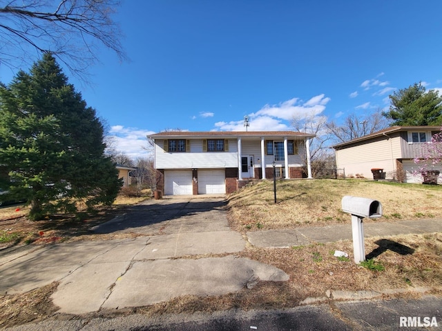 2827 W Larchmont Ln, Peoria, IL 61615 - bi-level home with an attached garage, asphalt driveway, and brick siding