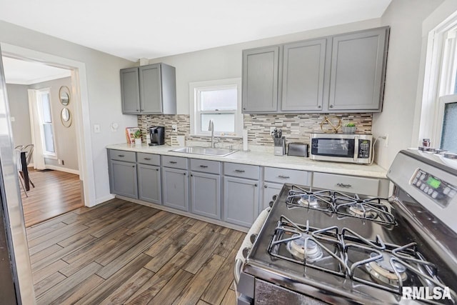 903 E Lake Ave, Peoria Heights, IL 61616 - kitchen with gray cabinets, appliances with stainless steel finishes, decorative backsplash, dark wood-style floors, and light countertops