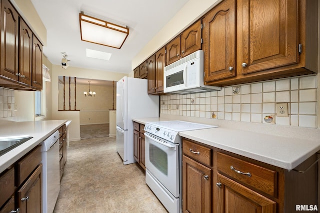 3524 W Saymore Ln, Peoria, IL 61615 - kitchen with white appliances, a chandelier, backsplash, light flooring, and light countertops