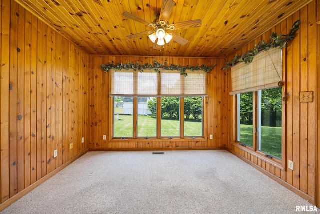 3524 W Saymore Ln, Peoria, IL 61615 - spare room with healthy amount of natural light, wood ceiling, wood walls, a ceiling fan, and carpet