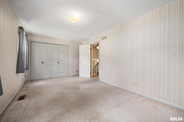 3524 W Saymore Ln, Peoria, IL 61615 - unfurnished bedroom featuring wallpapered walls, carpet floors, and a closet