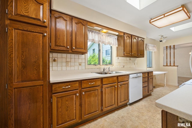 3524 W Saymore Ln, Peoria, IL 61615 - kitchen with white dishwasher, brown cabinets, decorative backsplash, and light countertops