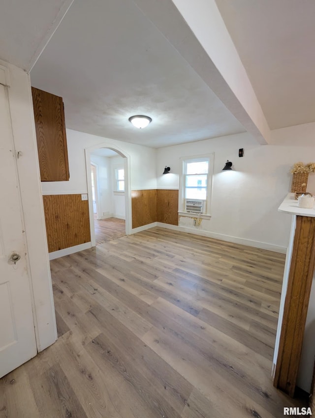 218 Meadow Lawn St, Manito, IL 61546 - unfurnished room with light wood-style floors, a wainscoted wall, arched walkways, wooden walls, and cooling unit