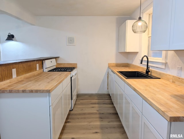 218 Meadow Lawn St, Manito, IL 61546 - kitchen featuring gas range gas stove, butcher block counters, light wood-style floors, white cabinets, and hanging light fixtures