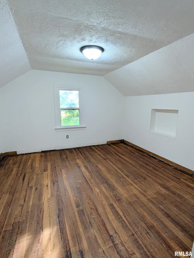 218 Meadow Lawn St, Manito, IL 61546 - additional living space with dark wood finished floors, vaulted ceiling, and a textured ceiling