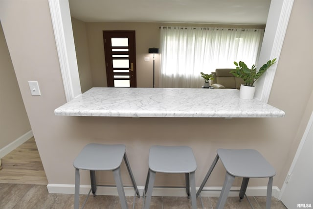 4527 N Nelson Dr, Peoria, IL 61614 - kitchen featuring a peninsula, a breakfast bar, and wood finished floors