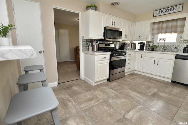 4527 N Nelson Dr, Peoria, IL 61614 - kitchen with stainless steel appliances, backsplash, light countertops, and white cabinets