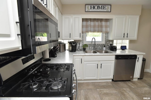 4527 N Nelson Dr, Peoria, IL 61614 - kitchen with stainless steel appliances, white cabinetry, backsplash, and light countertops