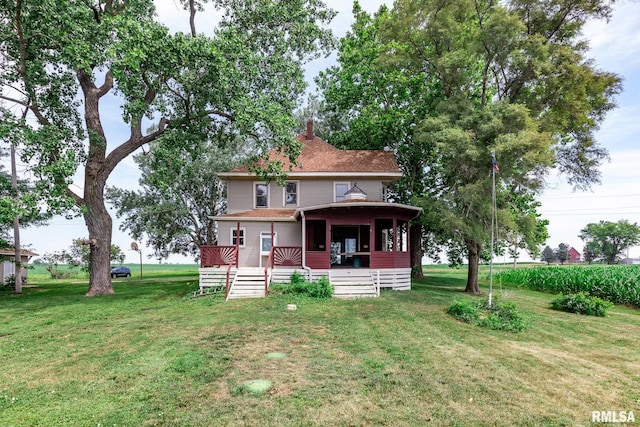 5610 W Lakeshore Dr, Princeville, IL 61559 - rear view of house featuring a yard, a chimney, and a shingled roof