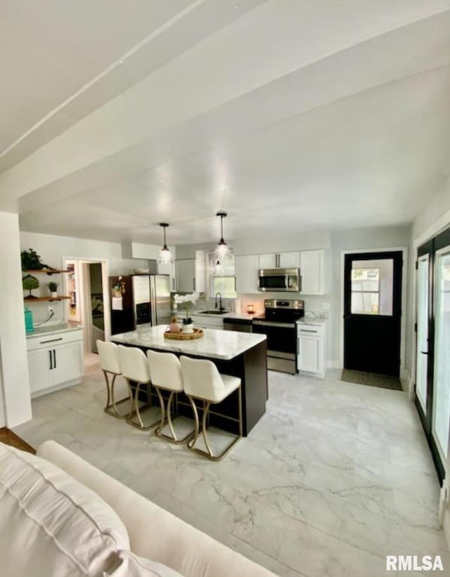 600 E Jefferson St, Washington, IL 61571 - kitchen with stainless steel appliances, light marble finish floors, a center island, white cabinetry, and pendant lighting