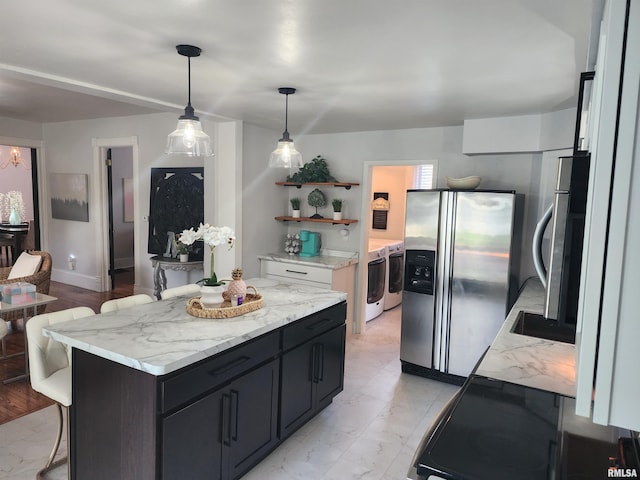 600 E Jefferson St, Washington, IL 61571 - kitchen with appliances with stainless steel finishes, washing machine and clothes dryer, open shelves, a breakfast bar, and light marble finish flooring