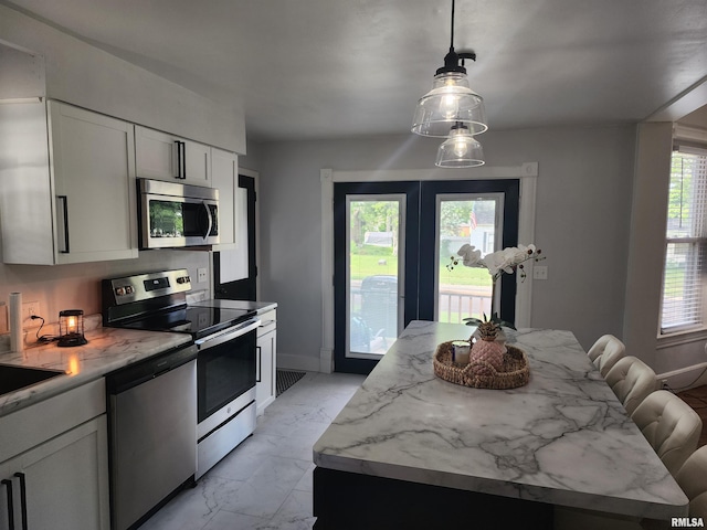 600 E Jefferson St, Washington, IL 61571 - kitchen featuring stainless steel appliances, light marble finish floors, white cabinets, hanging light fixtures, and a center island