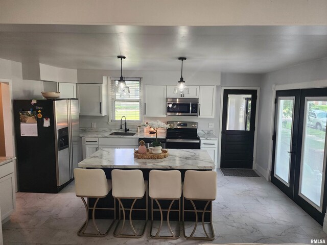600 E Jefferson St, Washington, IL 61571 - kitchen featuring stainless steel appliances, light marble finish flooring, white cabinets, light stone countertops, and hanging light fixtures