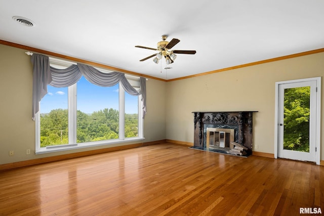 1426 N Main St, East Peoria, IL 61611 - unfurnished living room featuring healthy amount of natural light, wood finished floors, ornamental molding, ceiling fan, and a high end fireplace